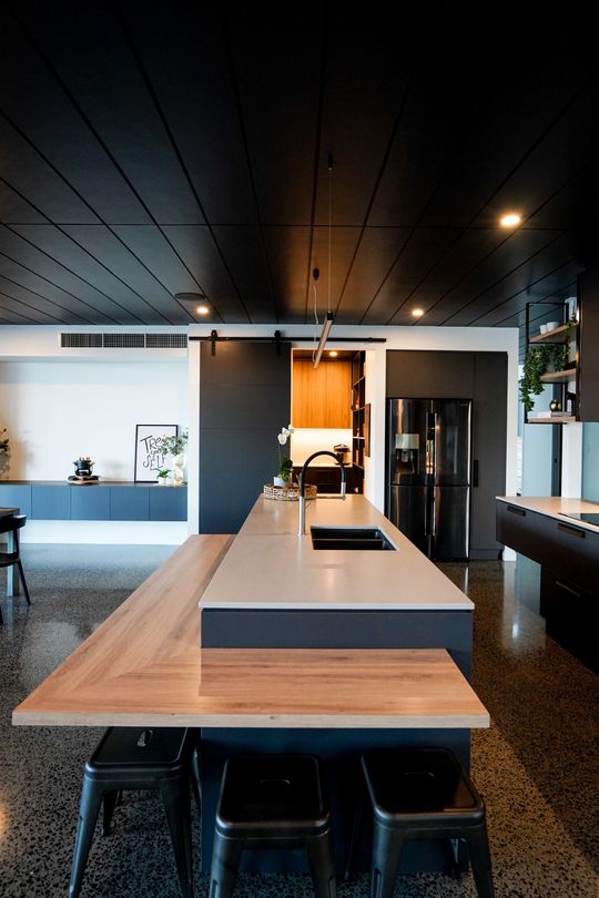Modern kitchen with light wood cabinets, stone countertop, and built-in tall pantry cabinet Modern kitchen with light wood cabinets, stone countertop, and built-in tall pantry cabinet