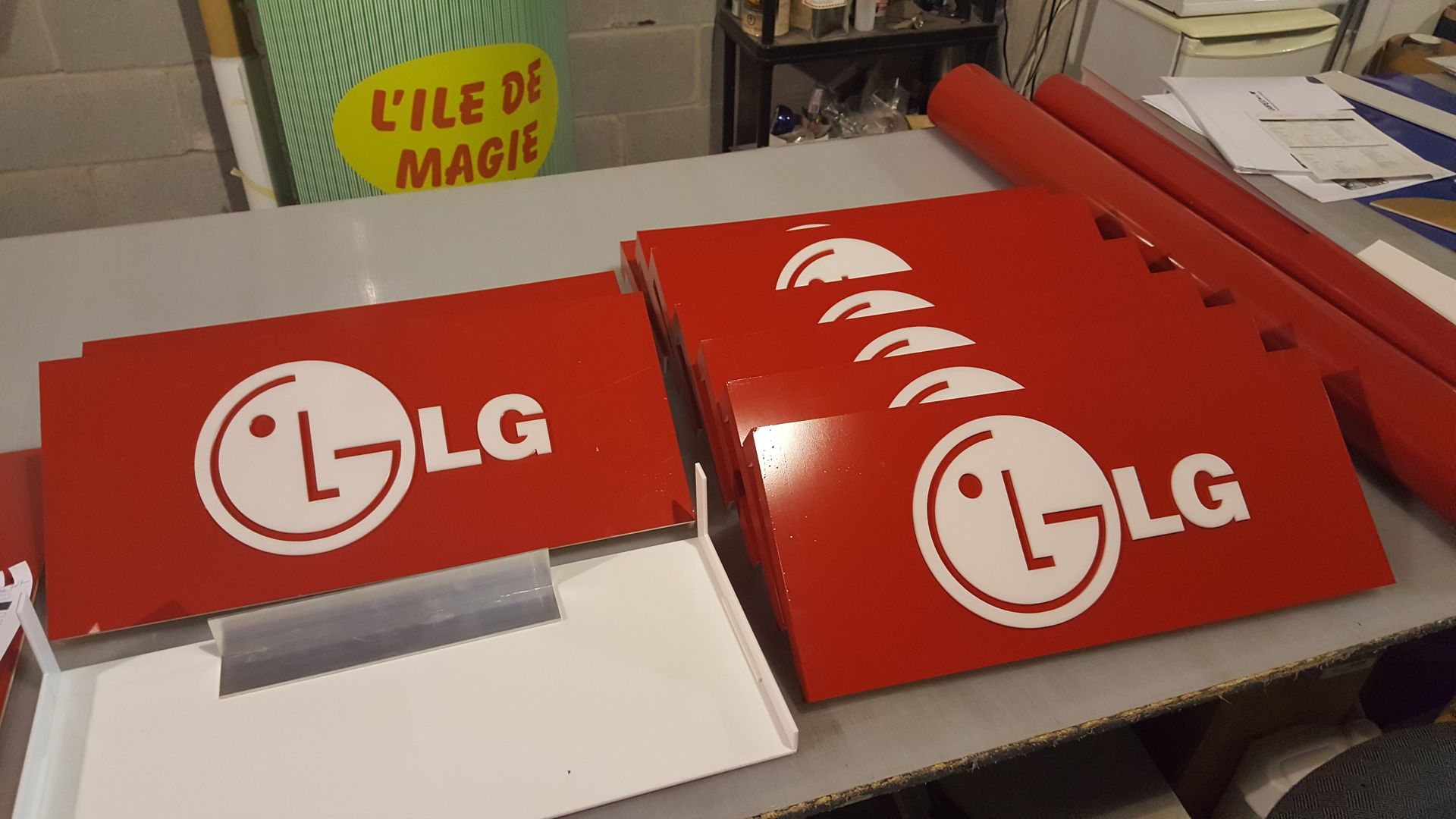 Red LG signage components, some stacked, with a white logo, on a table.