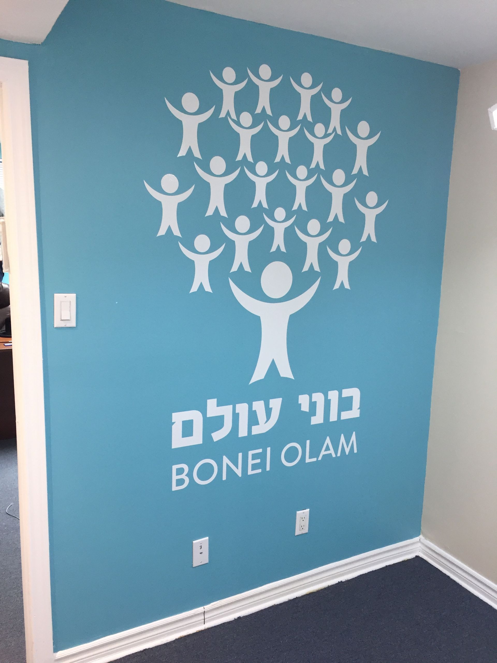White figures forming a tree on a blue wall, 