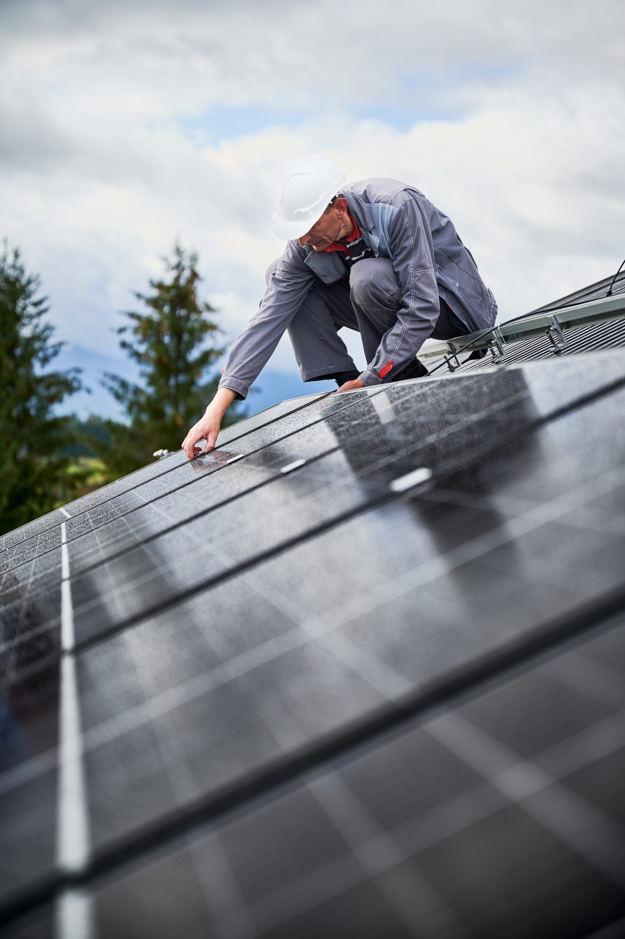 Roofing technician fastening panels along the slope of a roof