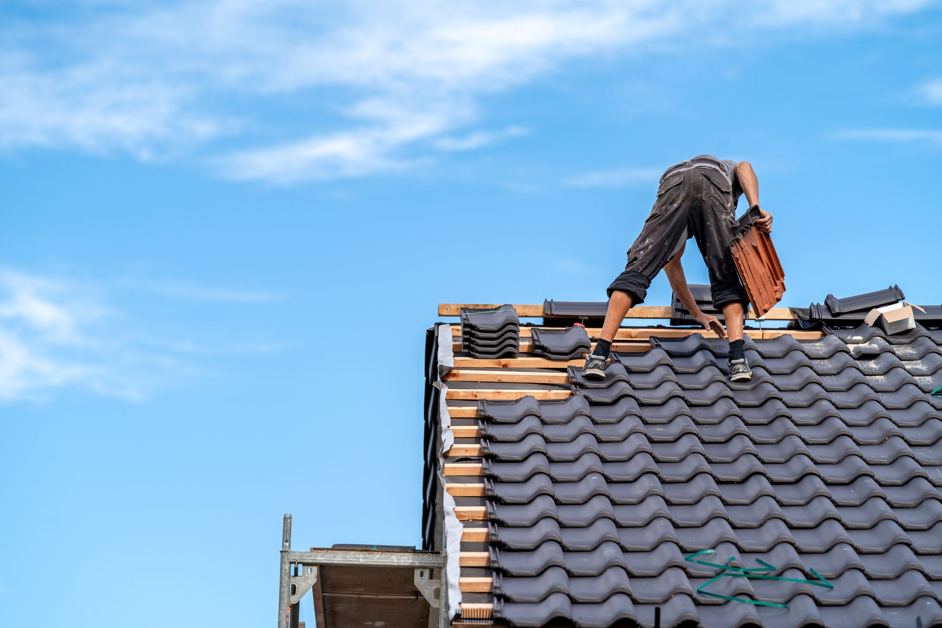 Roofer installing tiles on a residential roof