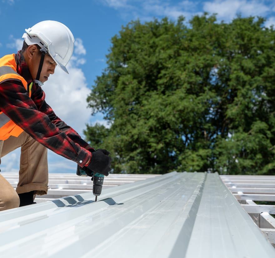 Roof Replacement in Florence, OR - roofer fastening metal roofing panels