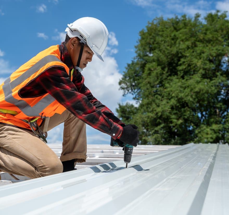 Roof Replacement in Florence, OR - roofer fastening metal roofing panels