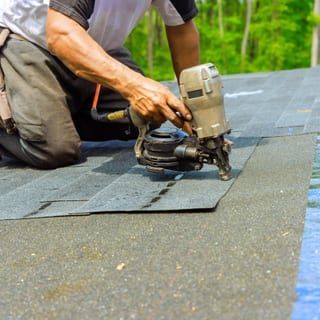 Roof Replacement in Waldport, OR - roofer installing shingles with a nail gun