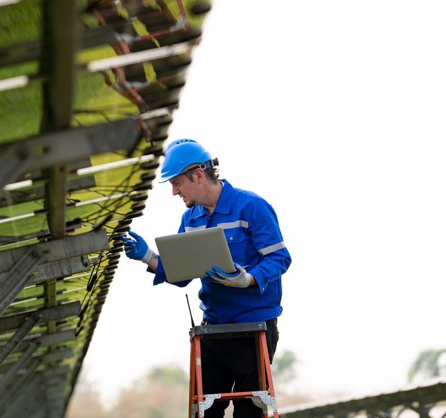 Roof Replacement in Waldport, OR - inspector with a laptop on a ladder