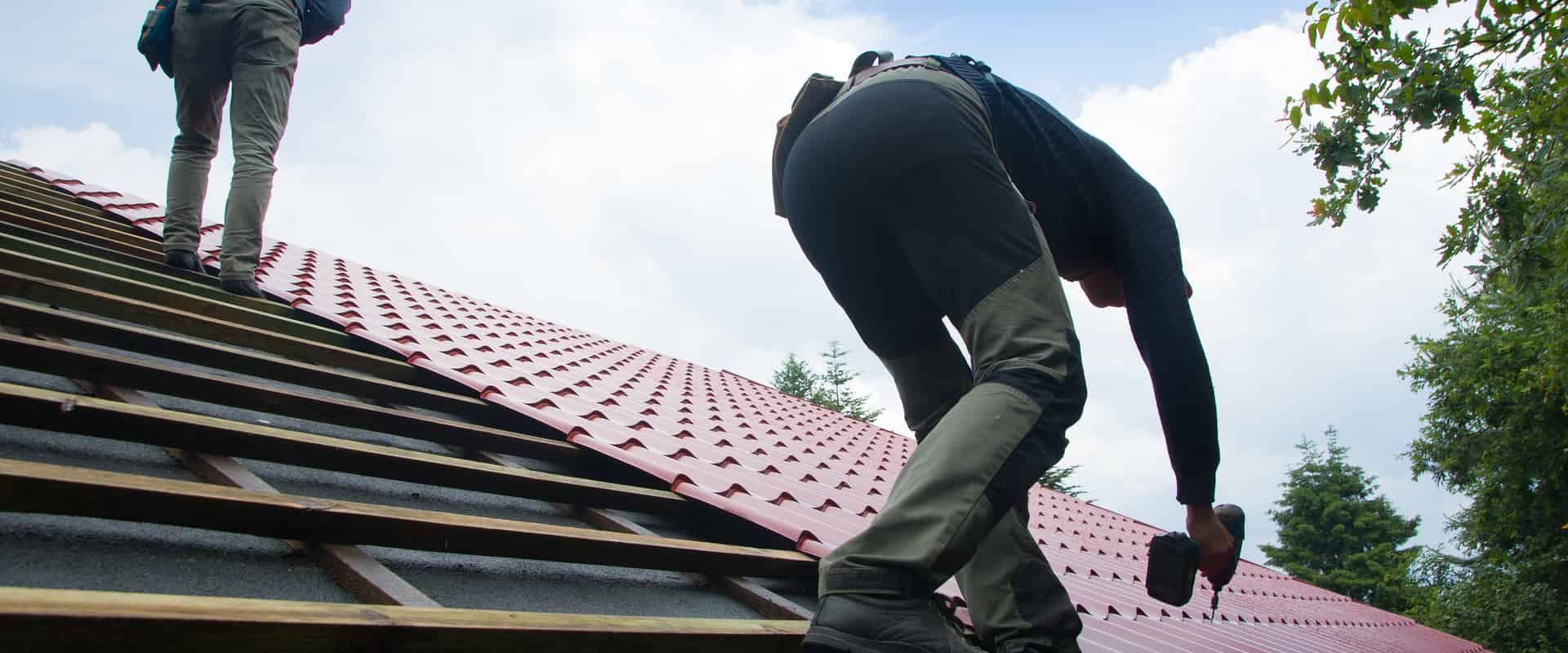 Roof Replacement in Waldport, OR - roofers installing red metal roofing