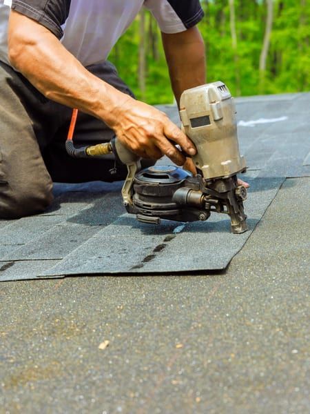 Roof Replacement in Waldport, OR - roofer installing shingles with a nail gun
