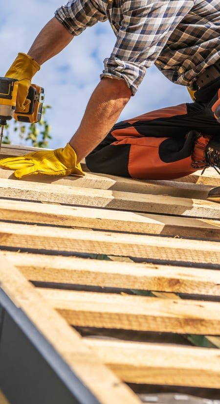 Roof Replacement in Waldport, OR - roofer driving screws into roof battens