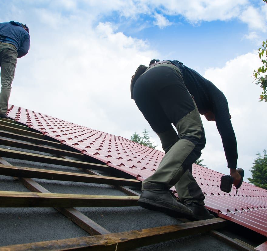 Roof Replacement in Waldport, OR - roofers installing red metal roofing