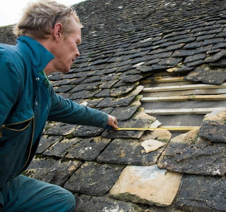 Roof Replacement in Waldport, OR - roofer measuring a damaged slate roof