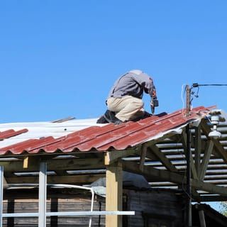 Roof Replacement in Yachats, OR - roofer installing roofing material on a house