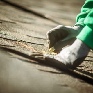 Roof Replacement in Yachats, OR - hands marking asphalt shingles for installation