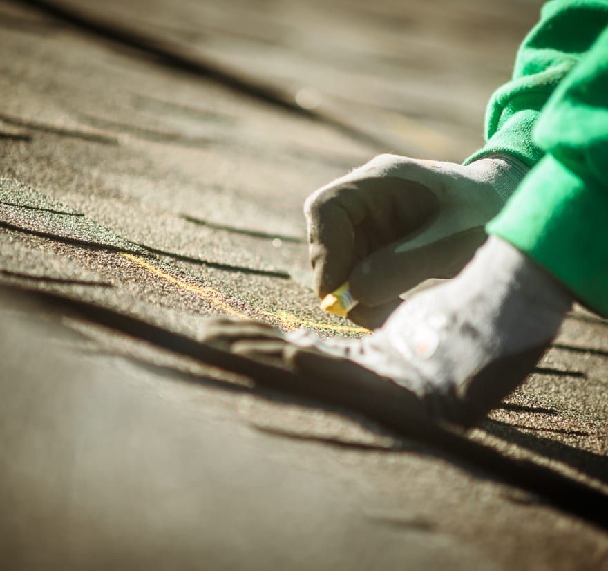 Roof Replacement in Yachats, OR - hands marking asphalt shingles for installation