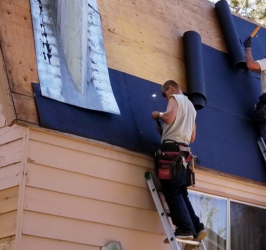 Roof Replacement in Yachats, OR - roofers installing underlayment on a house