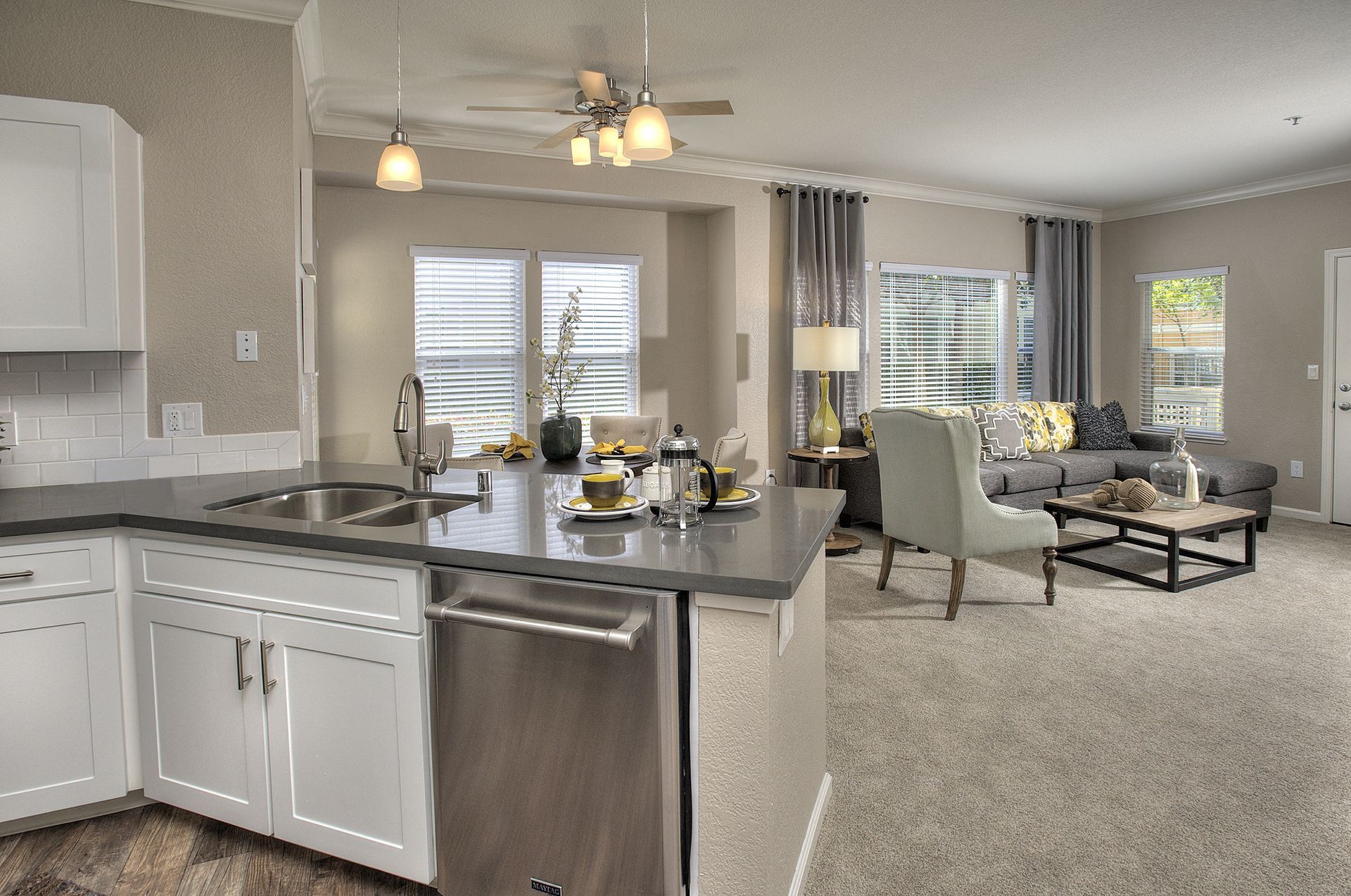 Open-concept kitchen with island and living room in a modern apartment at Iron Point at Prairie Oaks apartments in Folsom, CA.