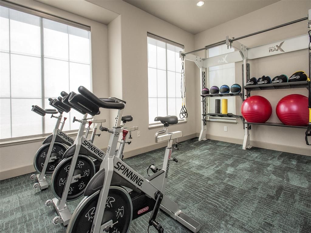Fitness room with spin bikes, medicine balls, and a rack of equipment at Iron Point at Prairie Oaks apartments in Folsom, CA.