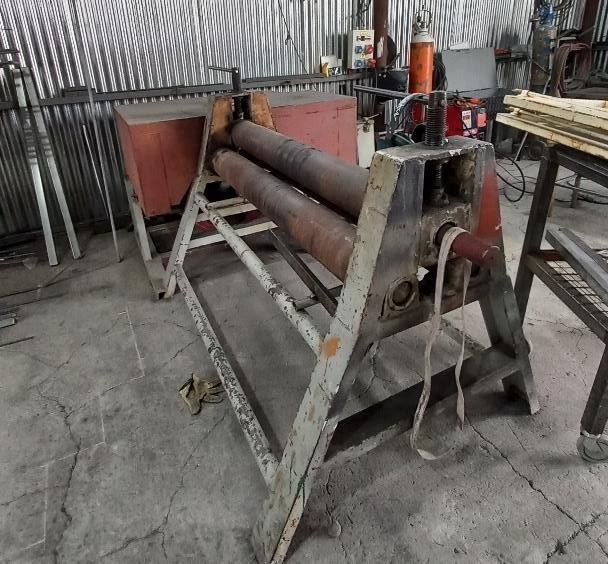 Máquina de rodillos metálicos en un taller. Diseño oxidado de tres rodillos
