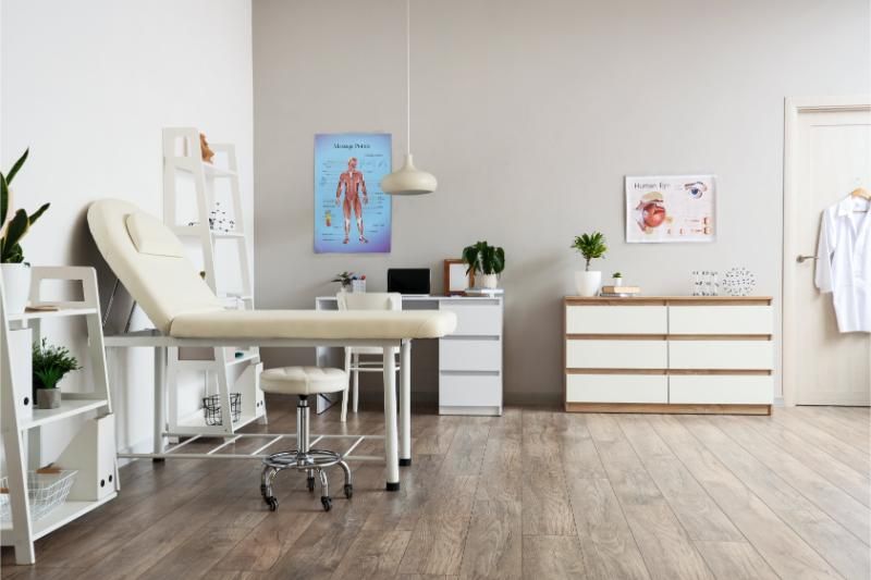 A doctor 's office with a couch and a desk.