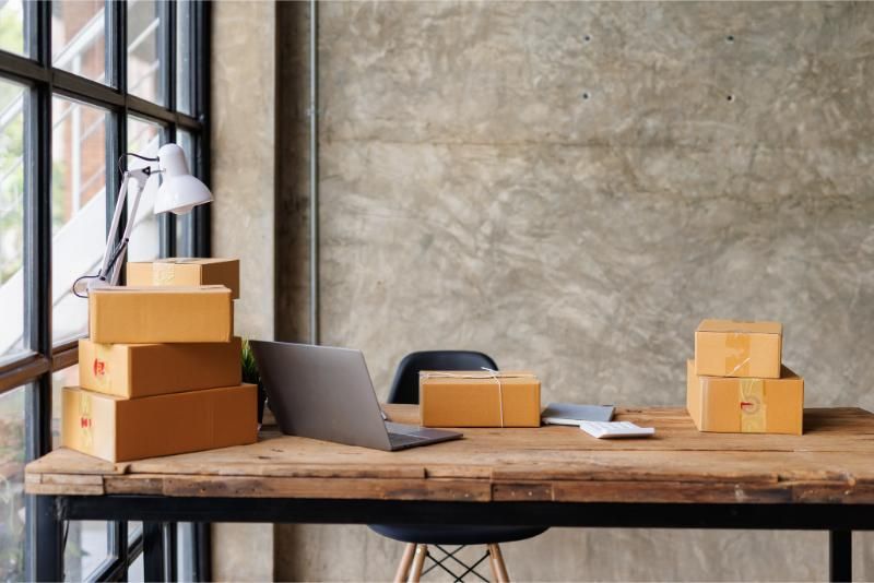 A wooden desk with boxes and a laptop on it.