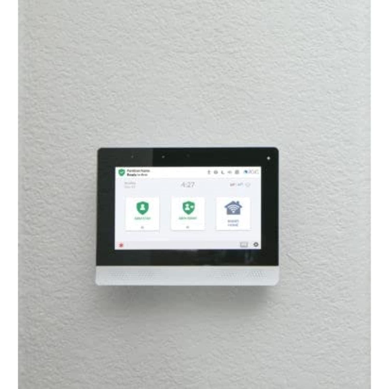 Wall-mounted touchscreen control panel with app icons on a white wall