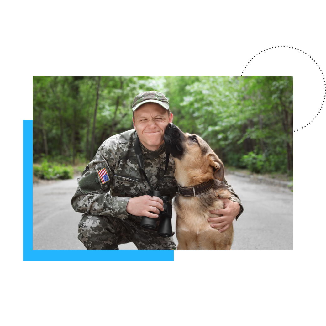 A soldier is kneeling down next to a dog. A soldier is kneeling down next to a dog.