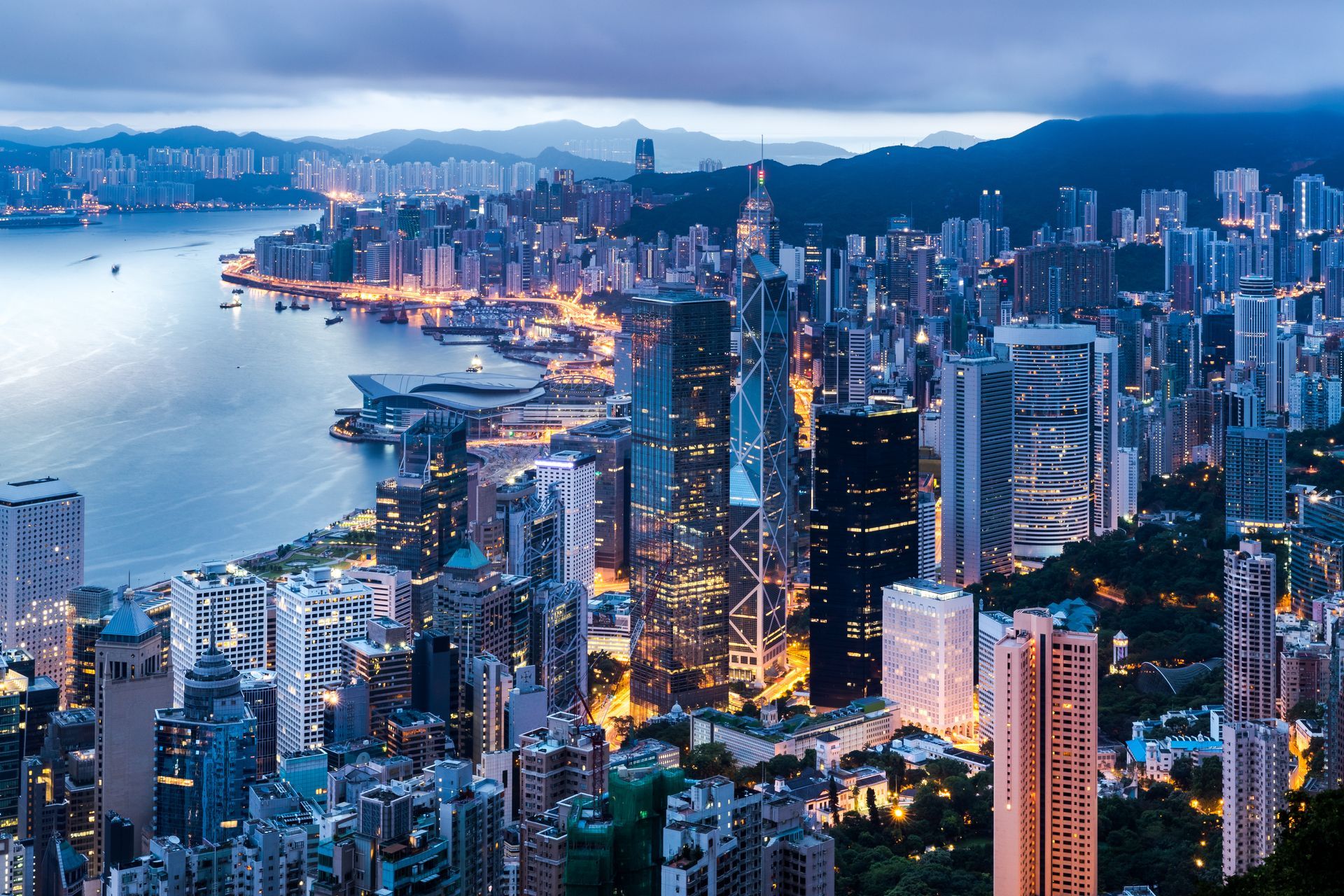 An aerial view of a city at night with a body of water in the background.