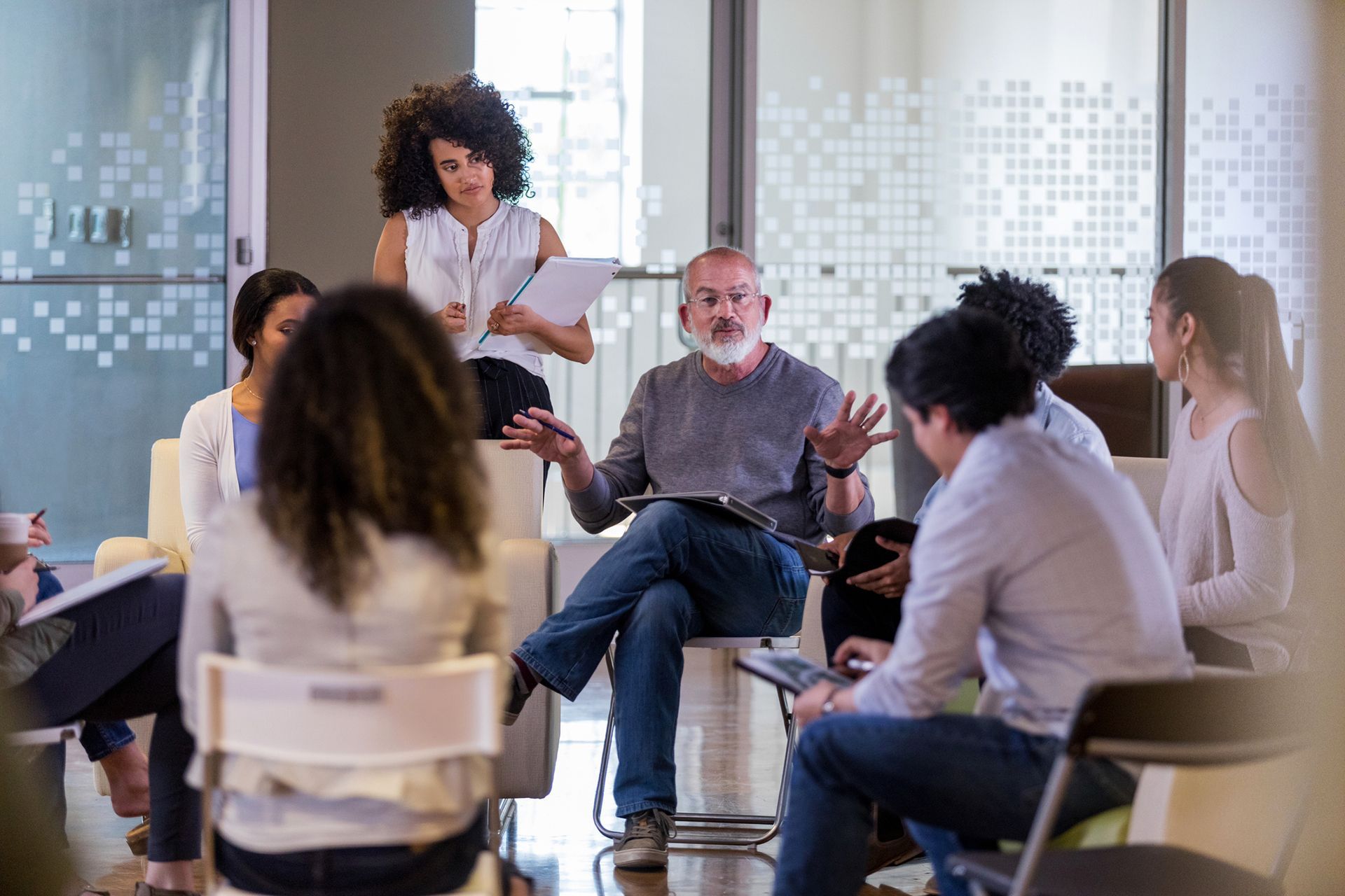 a group of people are sitting around a table at a on-site training session.