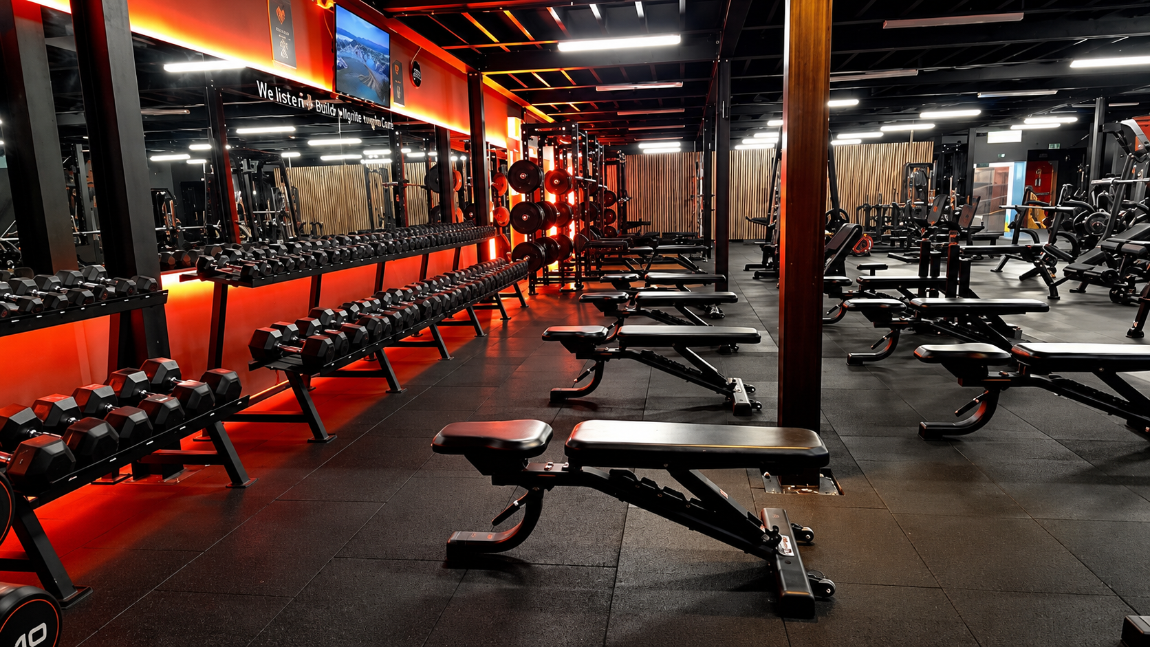 Dumbbell racks and benches in the free weights area at Fervid Fitness Flint