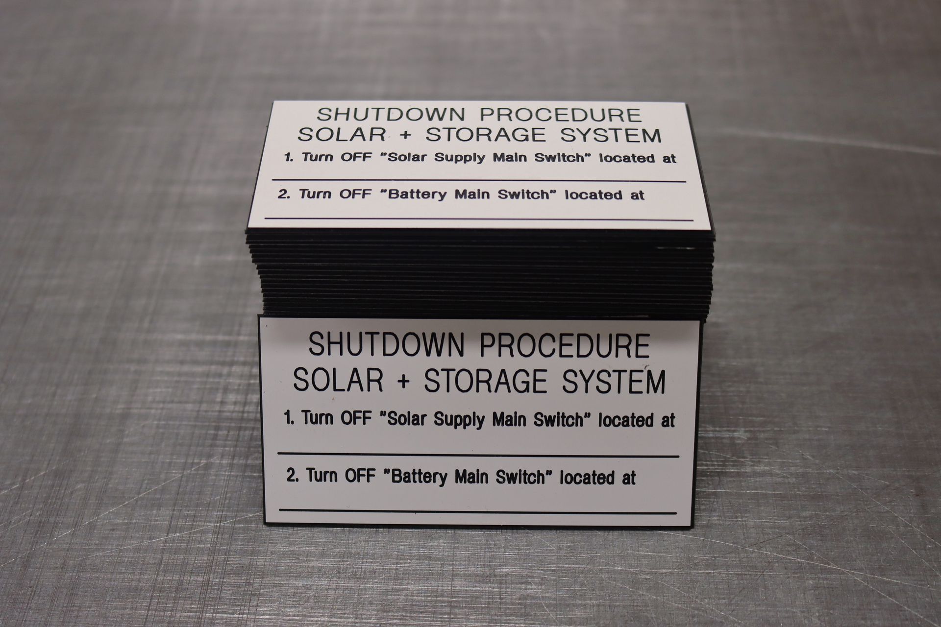 A stack of shutdown procedure solar + storage system labels 