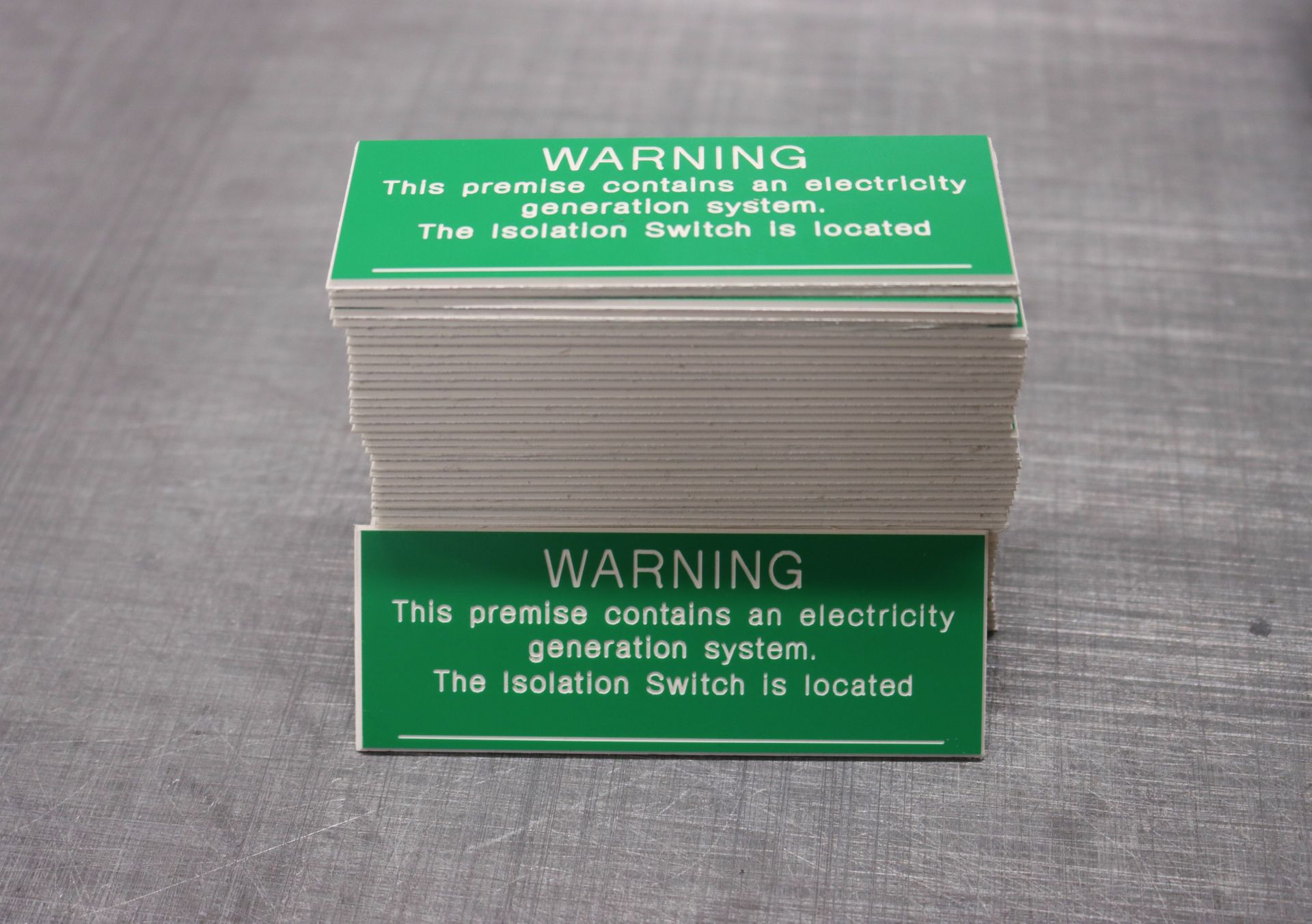 A stack of green warning signs on a table