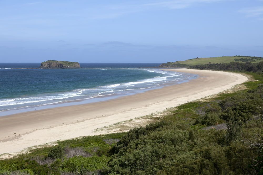 A Long Sandy Beach with A Small Island in The Distance — Brookes Engraving & Signs in Shellharbour, NSW