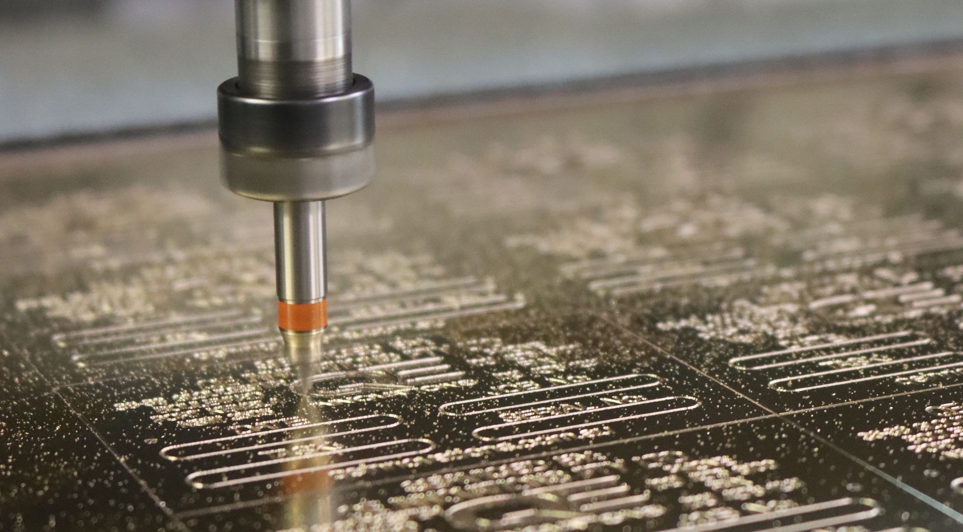 A machine is cutting a piece of metal on a table. 