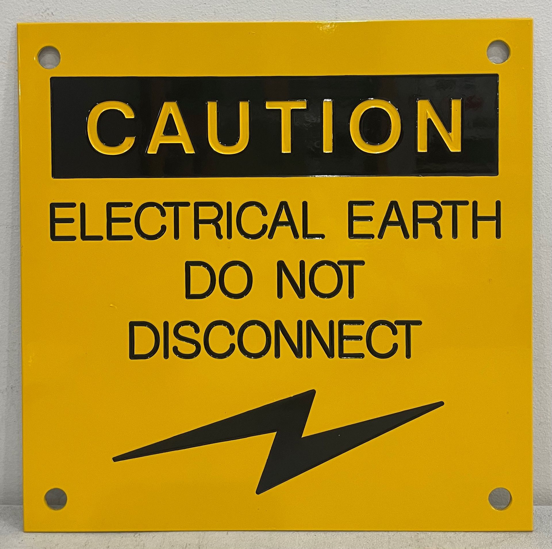 A yellow sign that says caution electrical earth do not disconnect 