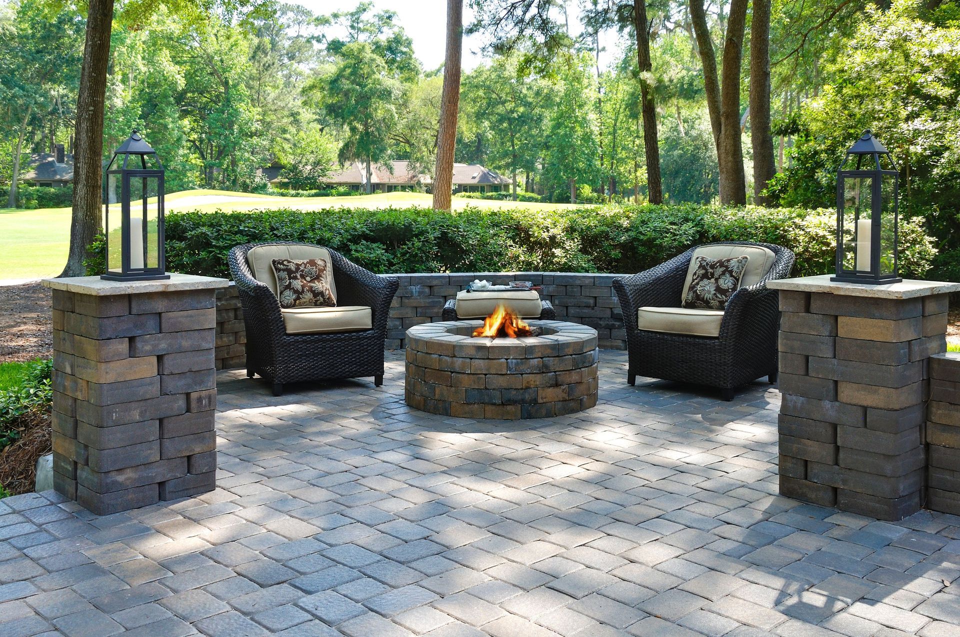 A custom paver patio and fire pit, surrounded by a retaining wall and masonry columns in Parker CO.