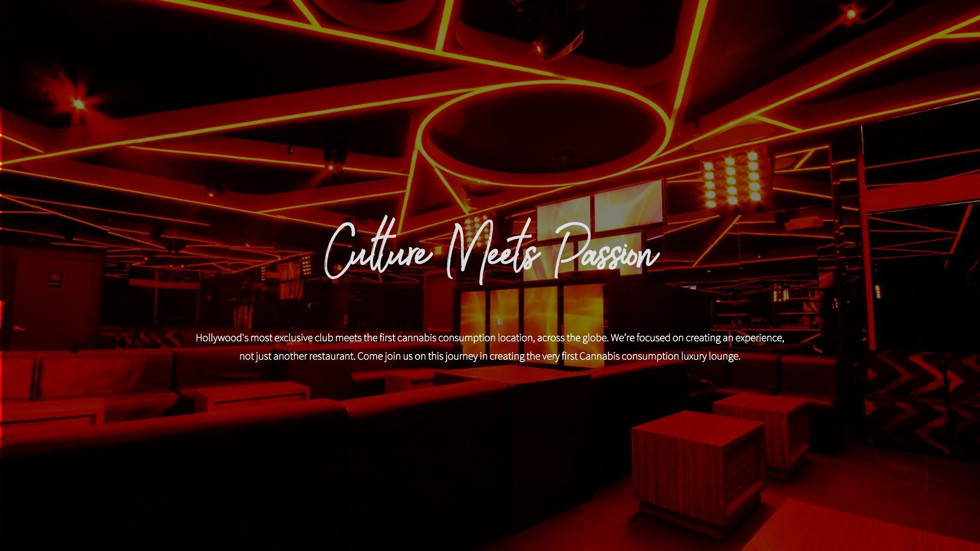 A dim, red-lit lounge with modern, angular ceiling lights, comfortable seating, and the text 