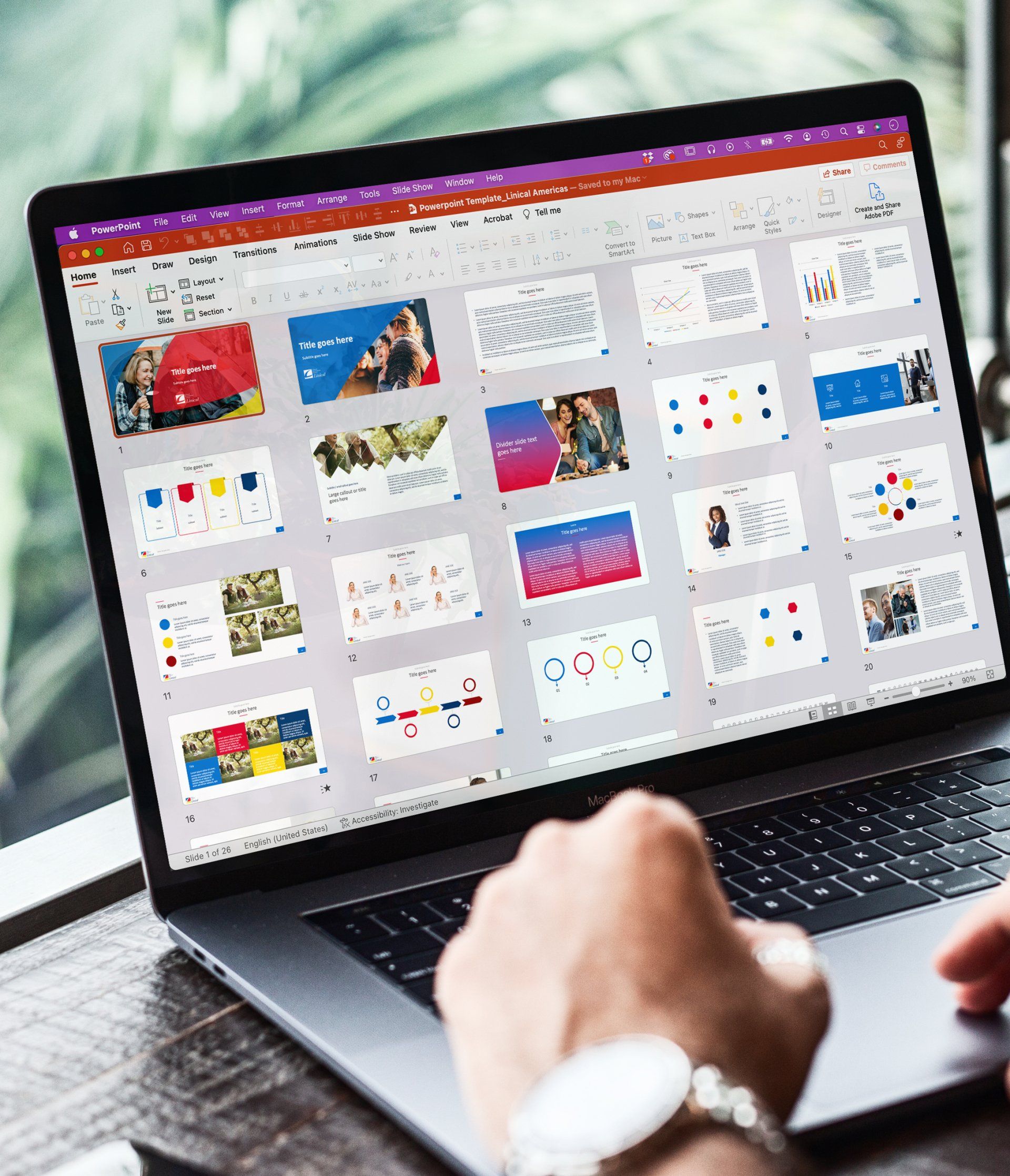 A person using a laptop displaying a PowerPoint presentation with multiple slides in a grid view.