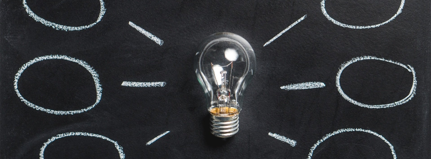 a light bulb is surrounded by circles on a blackboard .
