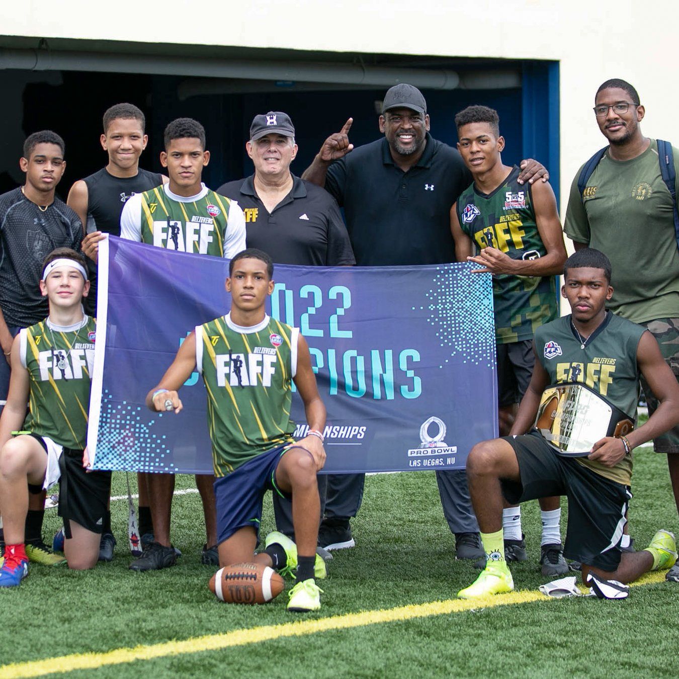 Believers athletes and coaches posing with a championship banner