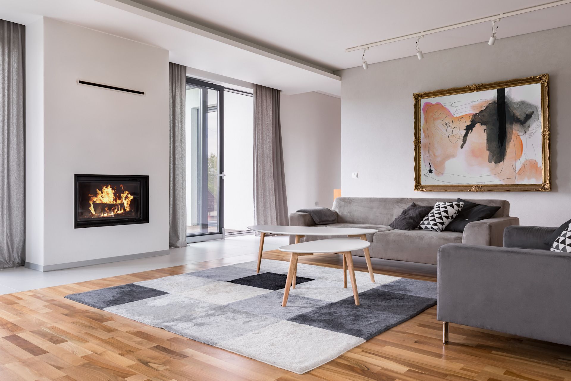 A living room with a couch , two chairs , a fireplace and a rug.