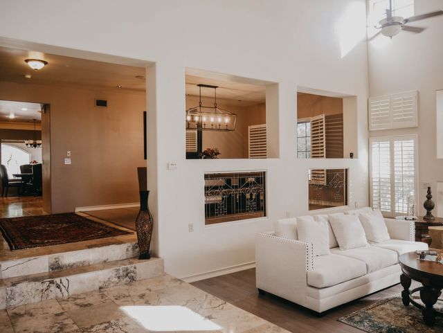 A living room with a white couch and a ceiling fan.