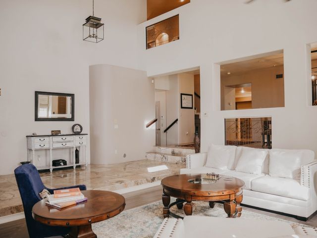 A living room with a couch , table , chair and mirror.