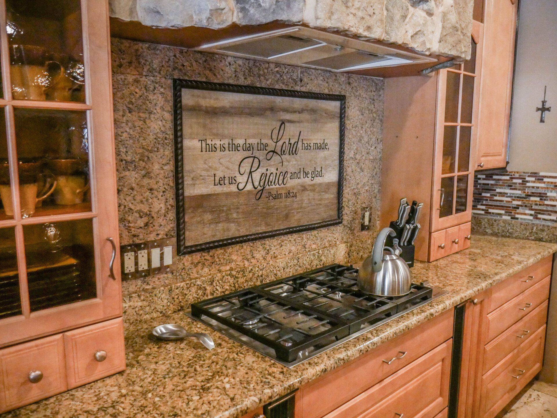 A kitchen with a stove top oven and a sign on the wall.