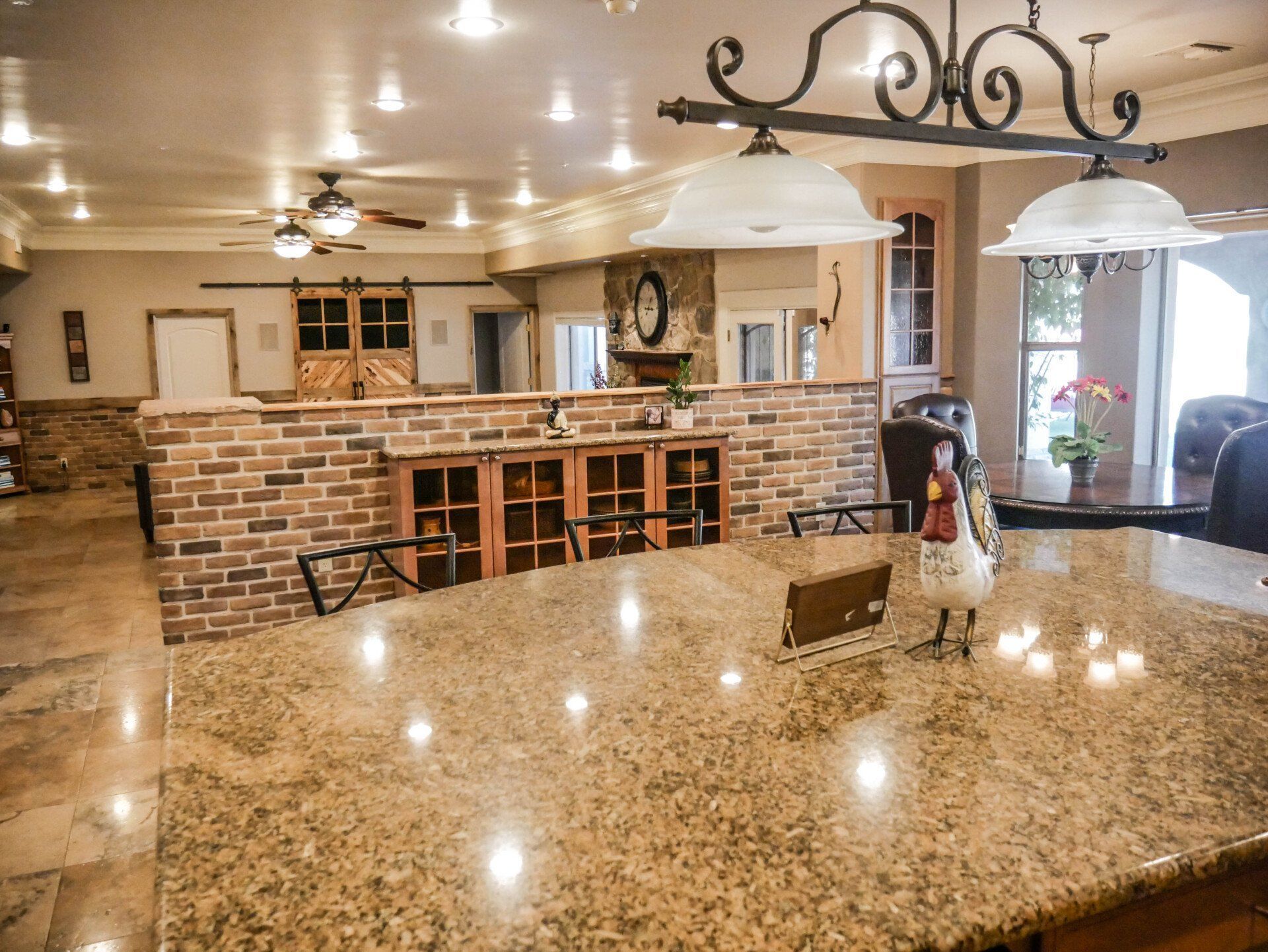 A kitchen with granite counter tops and a brick wall.