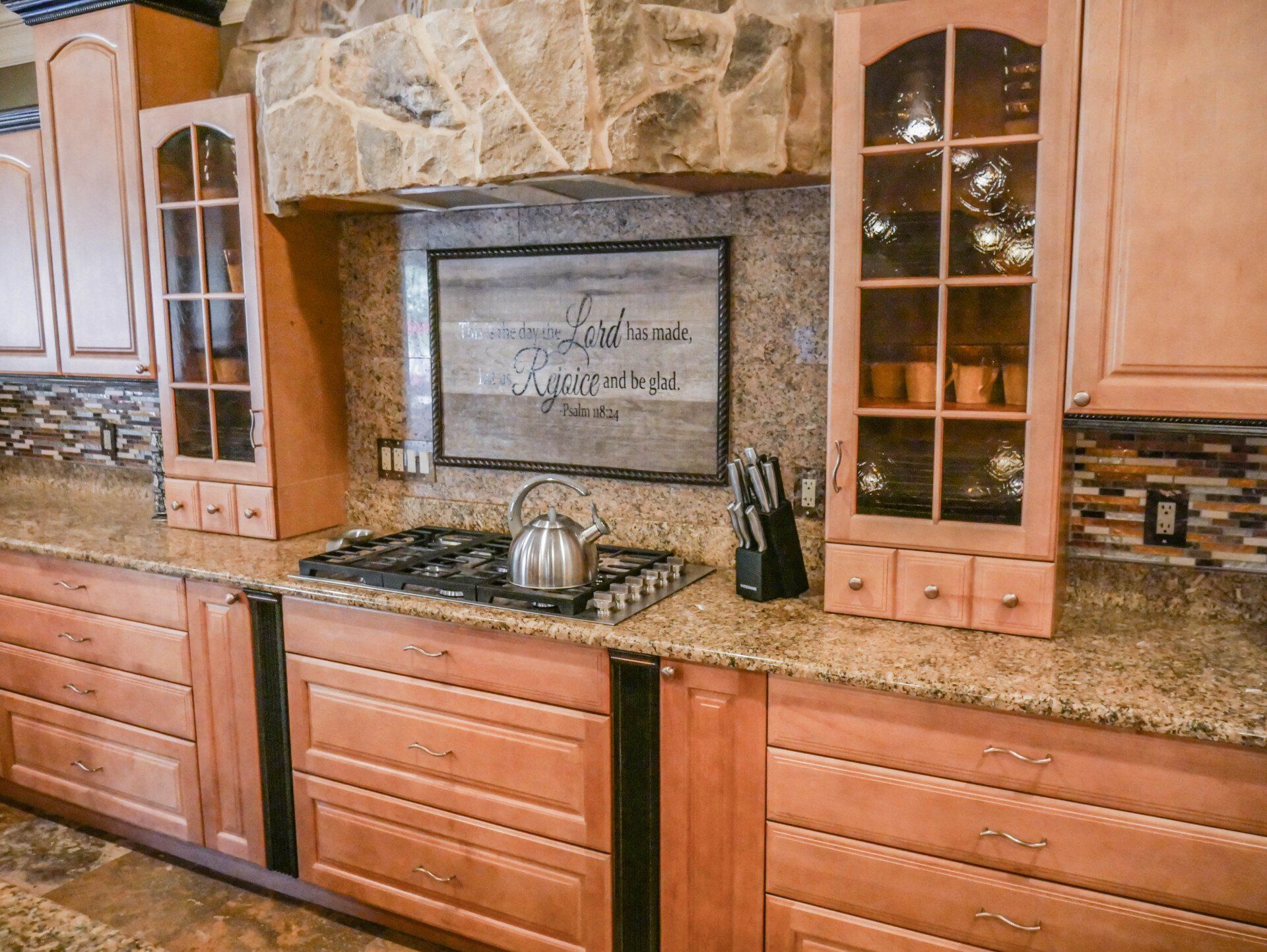 A kitchen with wooden cabinets and granite counter tops.