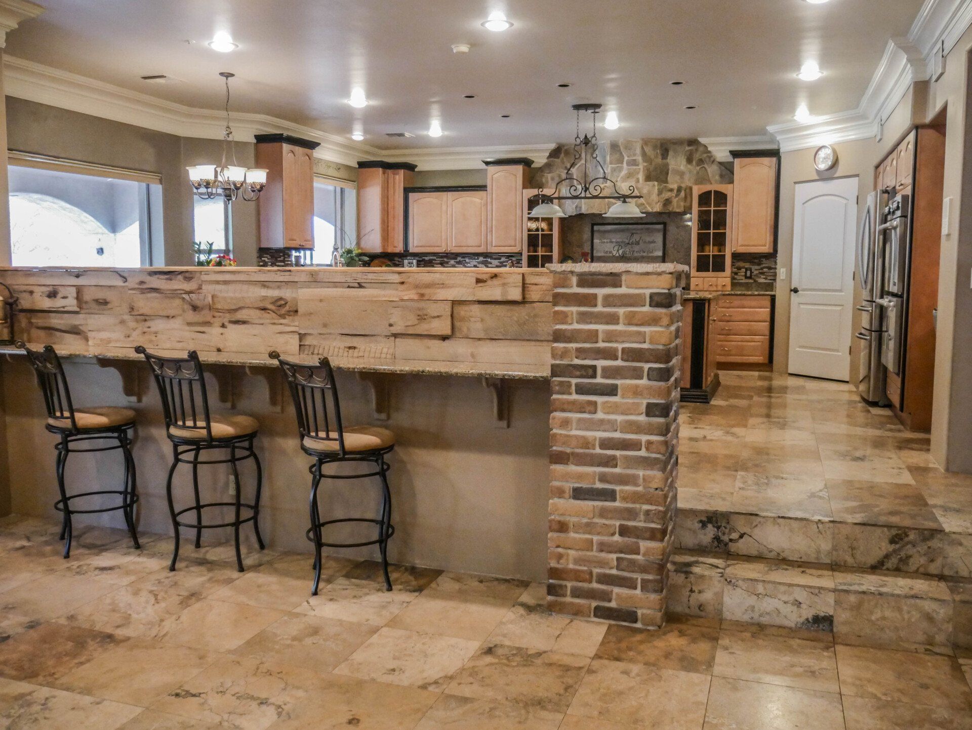 A kitchen with a brick wall and a wooden counter top.