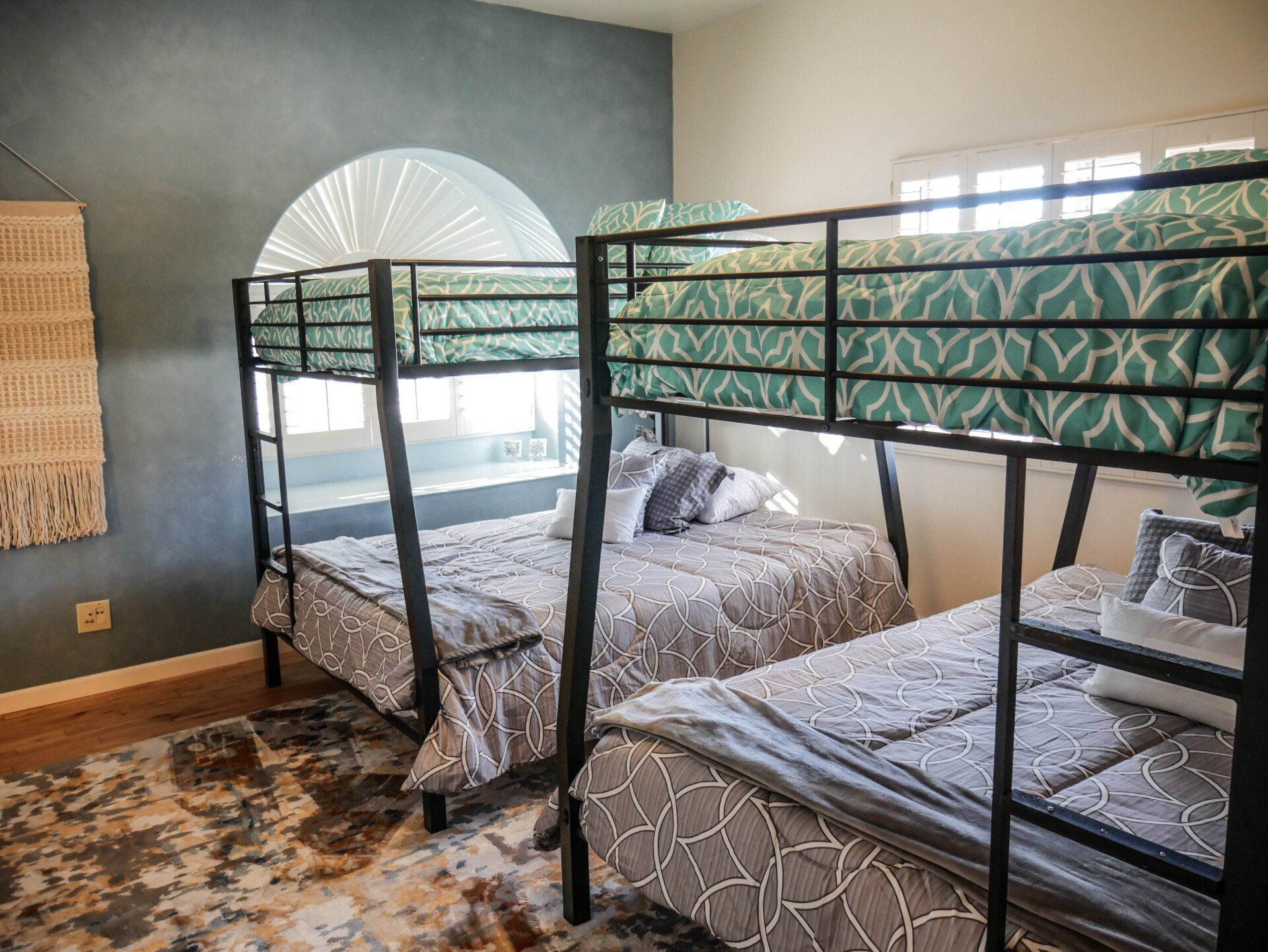 A bedroom with three bunk beds and a window.