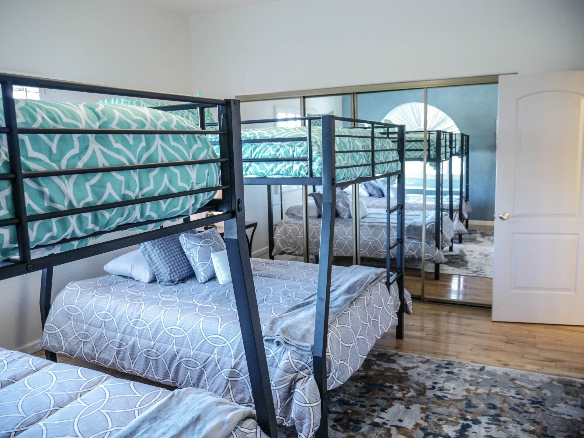 A bedroom with bunk beds and a large mirror.