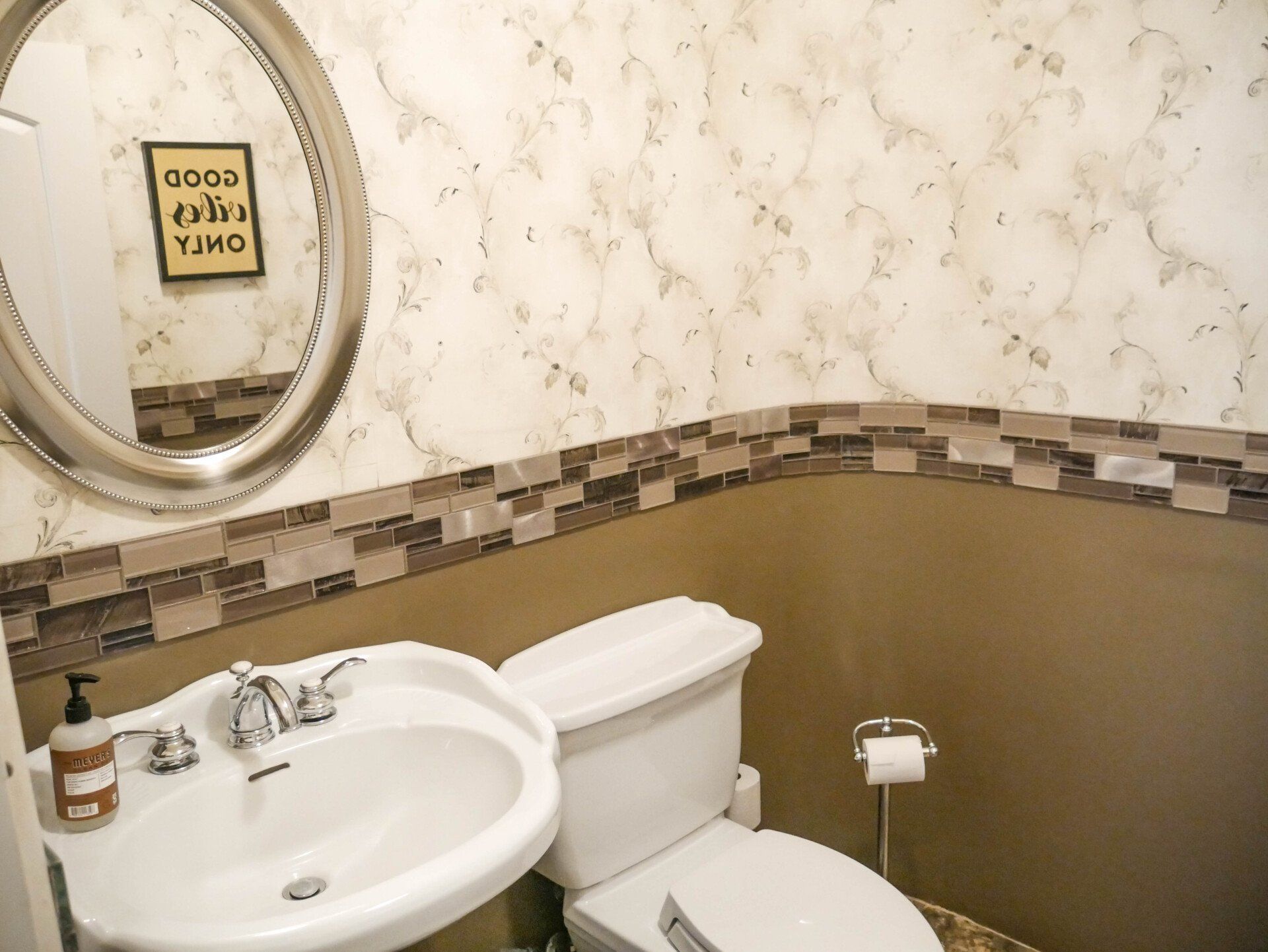 A bathroom with a toilet a sink and a mirror