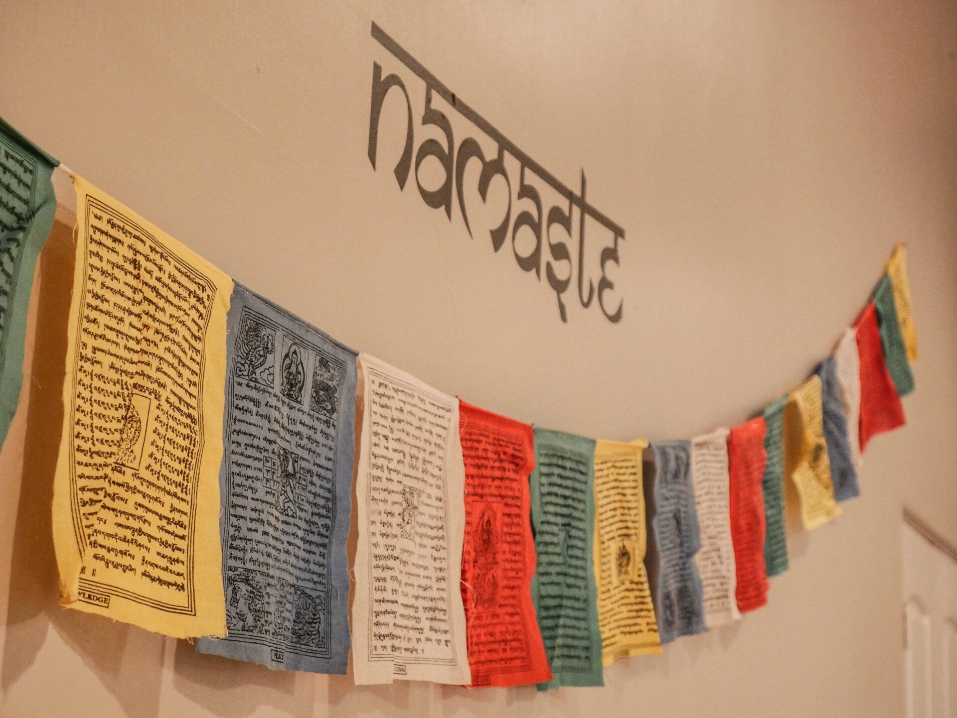 Colorful prayer flags hanging across a wall under the word “narrative”