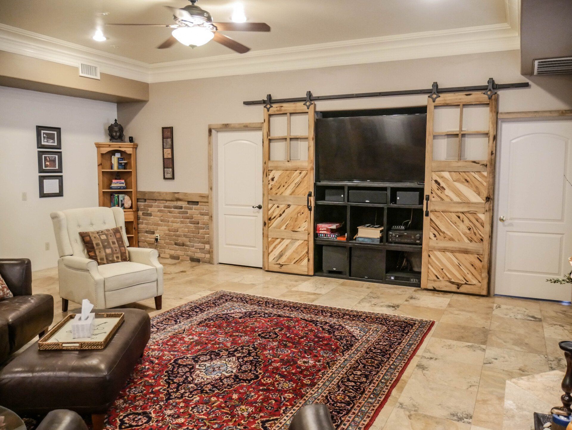 A living room with sliding barn doors and a flat screen tv.